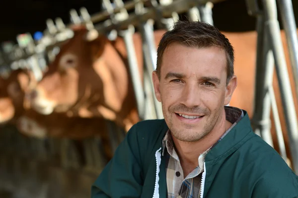 Portrait of smiling farmer with cows in background