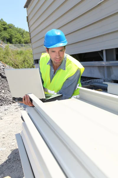 Engineer with laptop computer on building site