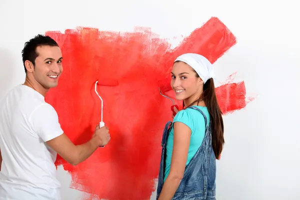 Couple having fun painting their new house