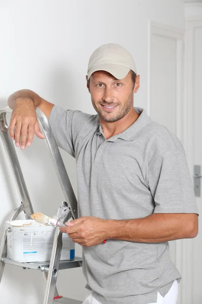 Man painting walls in white