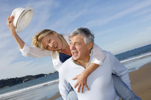 Portrait of cheerful senior couple having fun at the beach