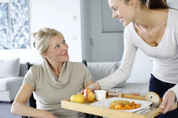 Young woman helping senior woman at home