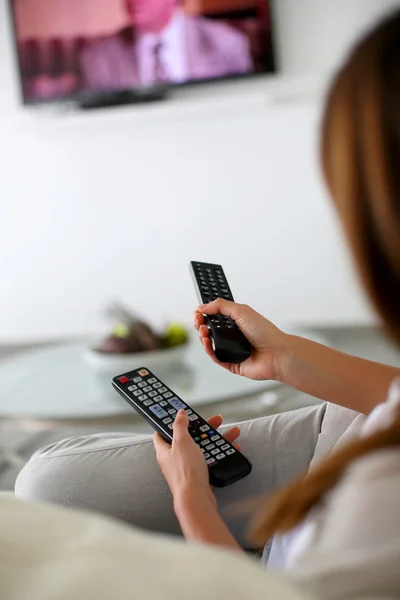 Closeup on remote control held by woman — Stock Photo #27918405