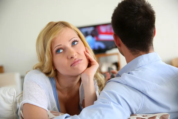 Blond woman being bored watching tv ith boyfriend