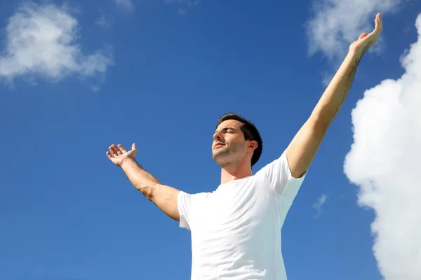 Man stretching arms up towards the sky
