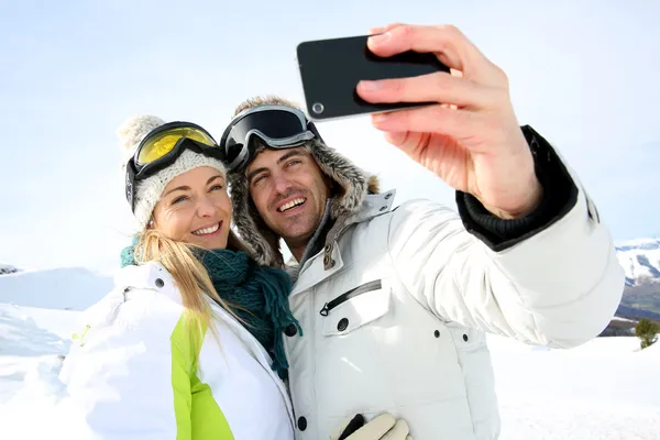 Skiers taking picture of themselves with smartphone
