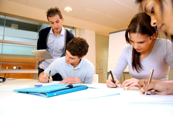 Teacher watching students writing exam