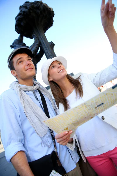 Couple visiting Madrid and checking on city plan