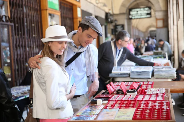 Tourists in Madrid walking by flea market