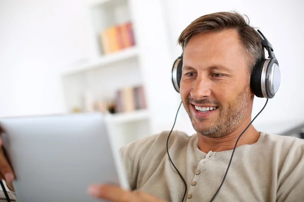 Man with tablet and headphones on