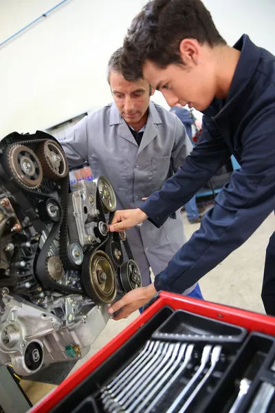 Teacher and student in auto mechanics training class