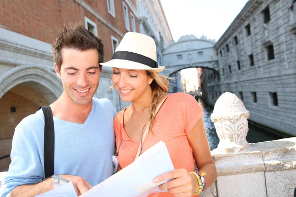 Couple looking at tourist guide by the Bridge of Sighs