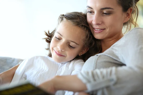 Mom with little girl reading book