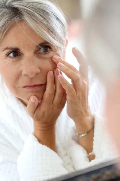 Woman applying anti-wrinkles cream