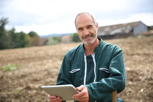 Farmer in field using digital tablet