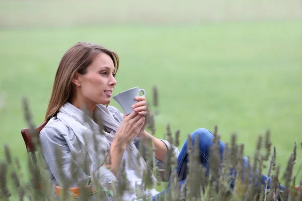 Woman drinking coffee in the garden
