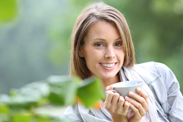 Woman drinking coffee in the garden