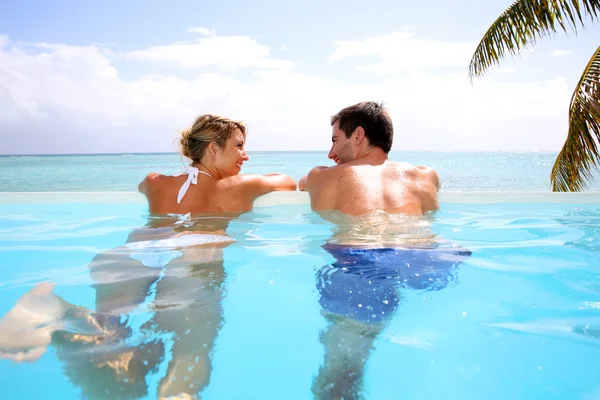 Couple swimming in infinity pool