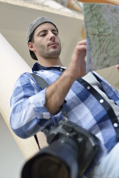 Photo reporter looking at street map