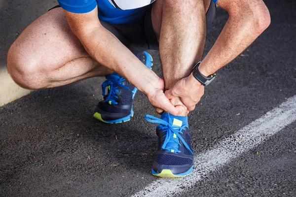 Broken twisted ankle - running sport injury. Male runner touchin