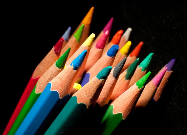 Top view of colored pencils, isolated on a black background