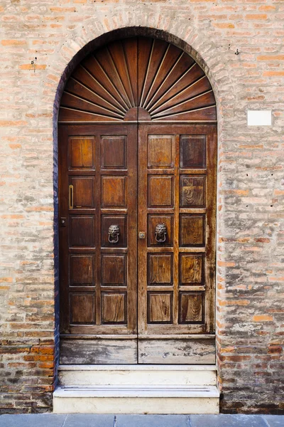 Wooden door in brick wall of medieval house