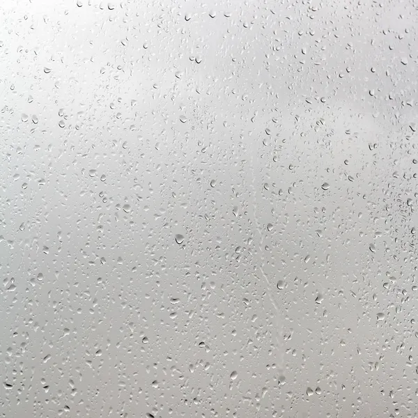 Rain drops on window pane in cloudy day