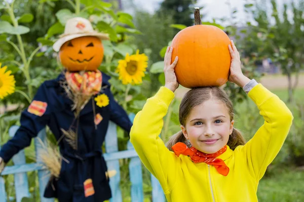 Scarecrow and happy girl in the garden