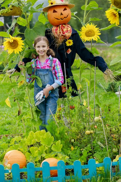 Scarecrow and happy girl in the garden