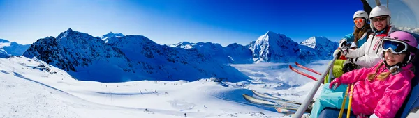 Skiing, ski lift, ski resort - happy skiers on ski lift