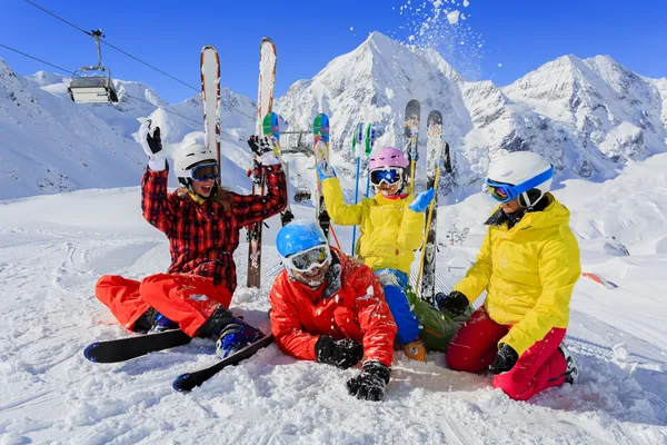 Skiing, skiers, sun and fun - family enyoing winter vacation