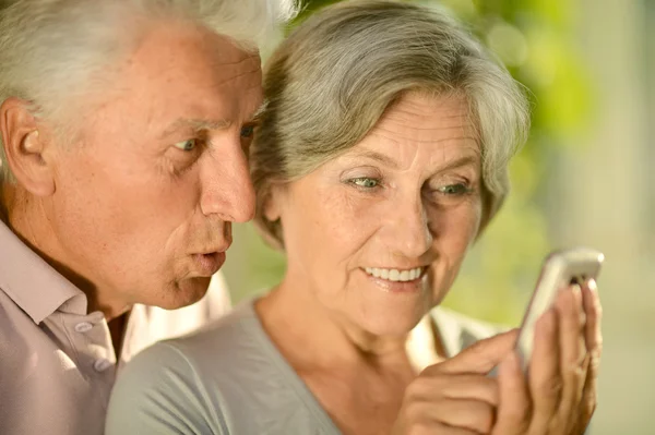 Happy elderly couple with a mobile phone