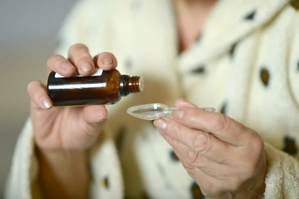 Closeup of woman's hands taking medicine