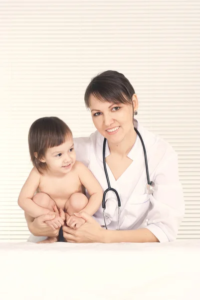 Pediatrician doctor with little girl in her office