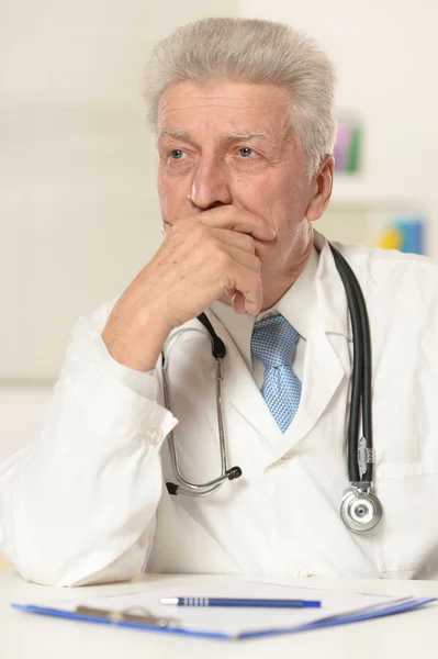 Elderly doctor at table