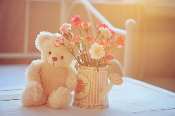 Still life with teddy bear and pink flowers