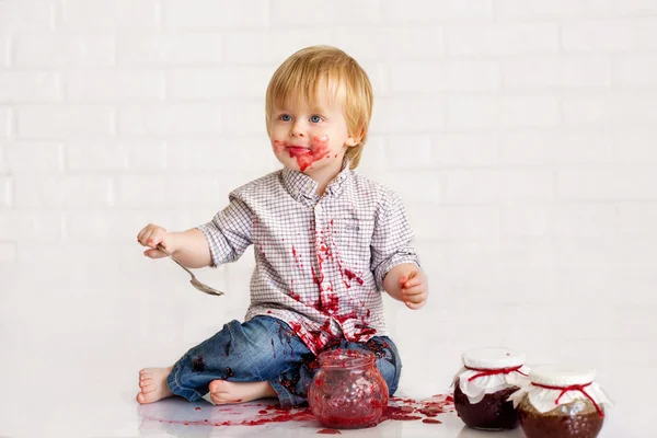 Boy  eating strawberry jam