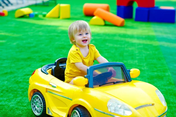 Kid in the yellow car on the playground