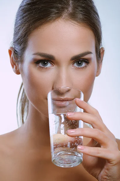 Healthy sport woman drinks cold mineral water from glass