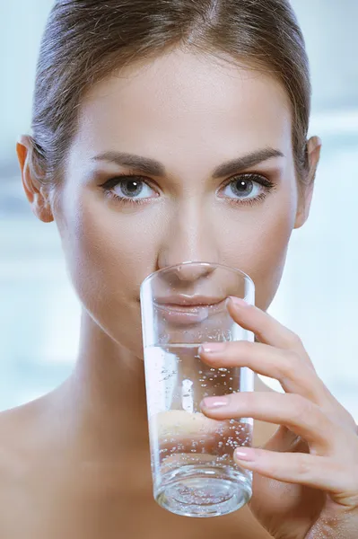 Healthy sport woman drinks cold water from glass