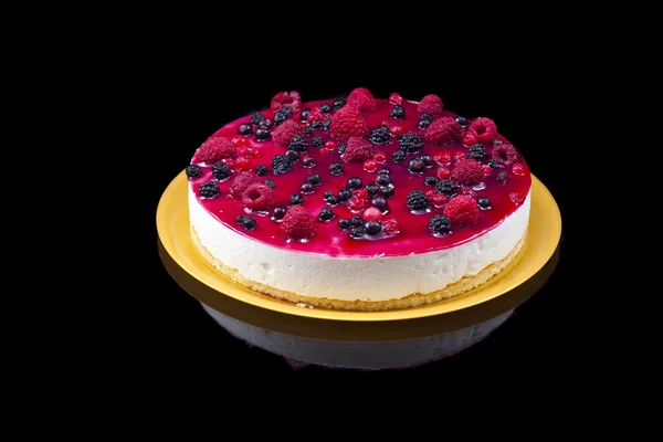 Cheese and red fruits cake, isolated on black