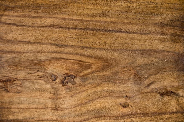 Wooden upper surface of an end table.
