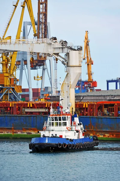 Tugboat assisting bulk cargo ship