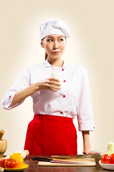 Asian female cook drinking milk