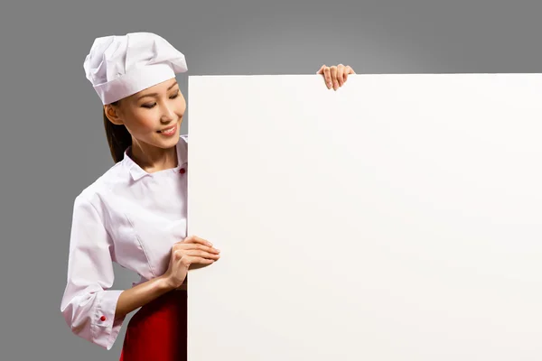 Female chef holding a poster for text