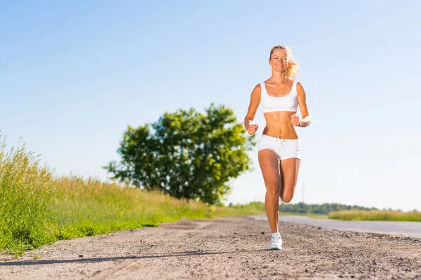 Young athletic woman running on the road