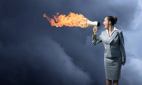 Business woman shouting into a megaphone