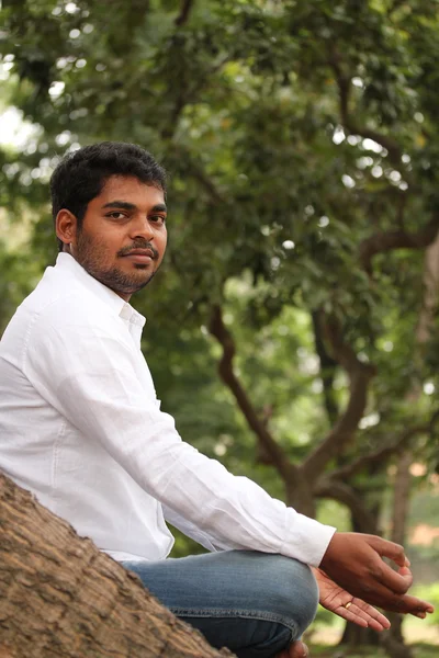 Close-up profile photo of a handsome indian man meditating under