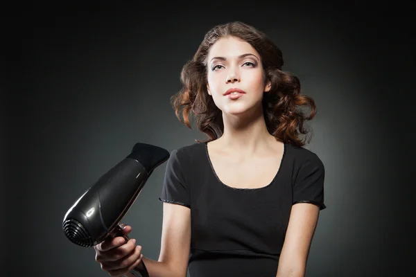 Girl dries hair by hair dryer
