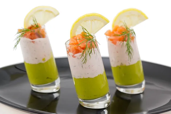 Salmon and avocado mousse on black plate